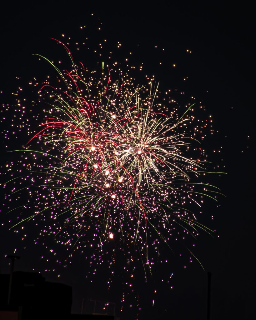 Colorful fireworks display lighting up the dark night sky, creating a festive and celebratory atmosphere.