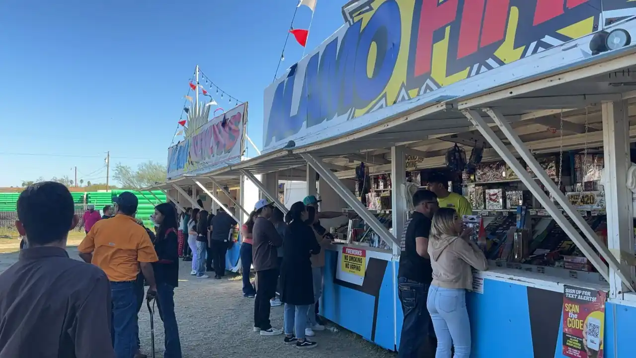 Customers lined up at an Alamo Fireworks stand on a sunny day
