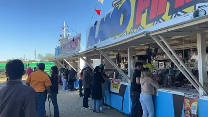 Customers lined up at an Alamo Fireworks stand on a sunny day