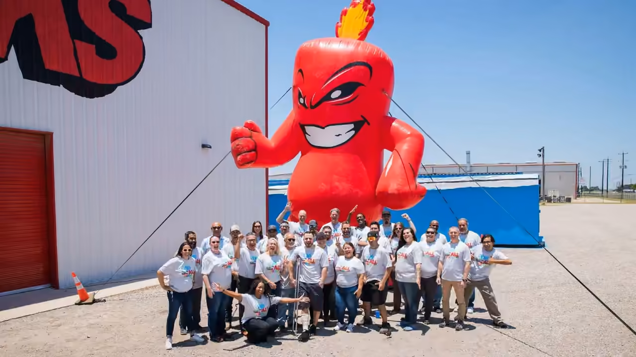 The Alamo Fireworks team posing with the giant inflatable Burst mascot